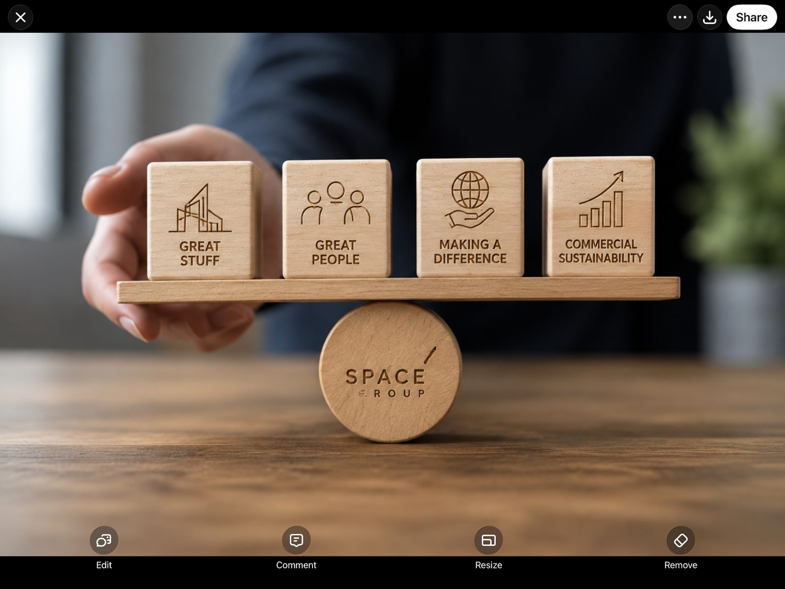 Four wooden blocks labelled Great Stuff, Great People, Making a Difference and Commercial Sustainability, balanced on a Space-branded pivot