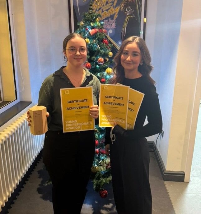 Two Spacers holding certificates of achievement