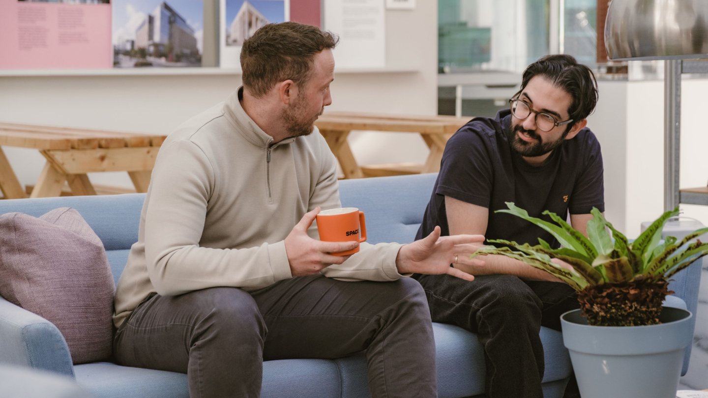 Two Spacers talking over coffee in the Spaceworks lounge